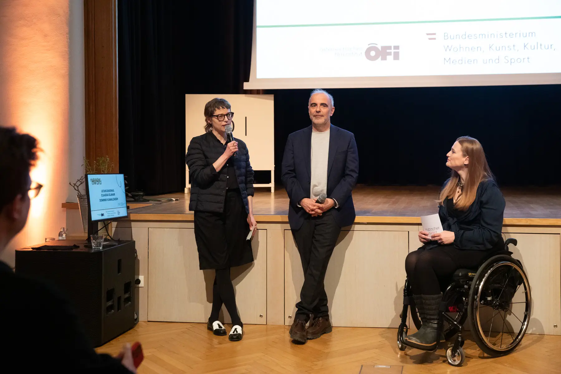 Claudia Slanar spricht auf der B&uuml;hne. Daneben steht Dominik Kamalzadeh.